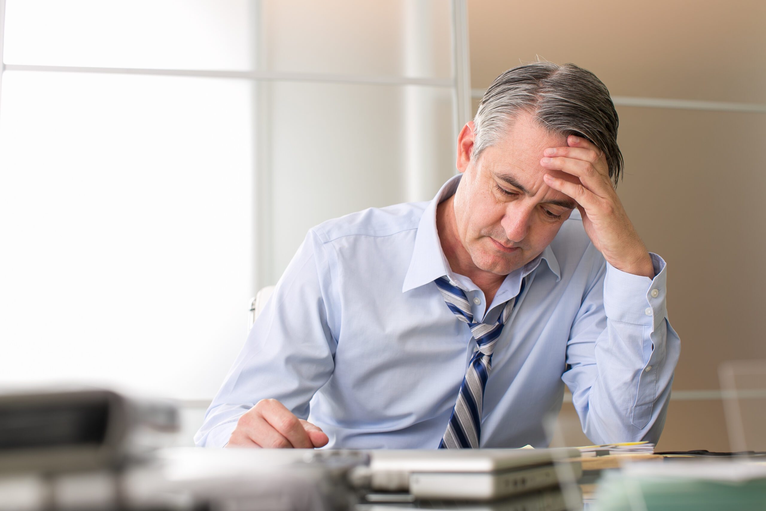 Frustrated stressed broker reviewing paperwork